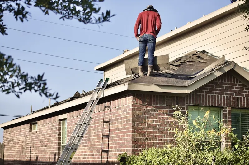 Professional roofer working on a residential roof in Gulfton